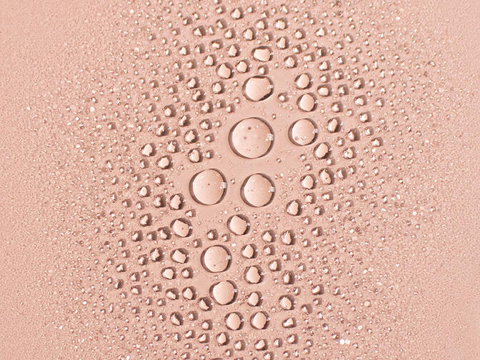 Cluster of mist droplets on a peach colored background